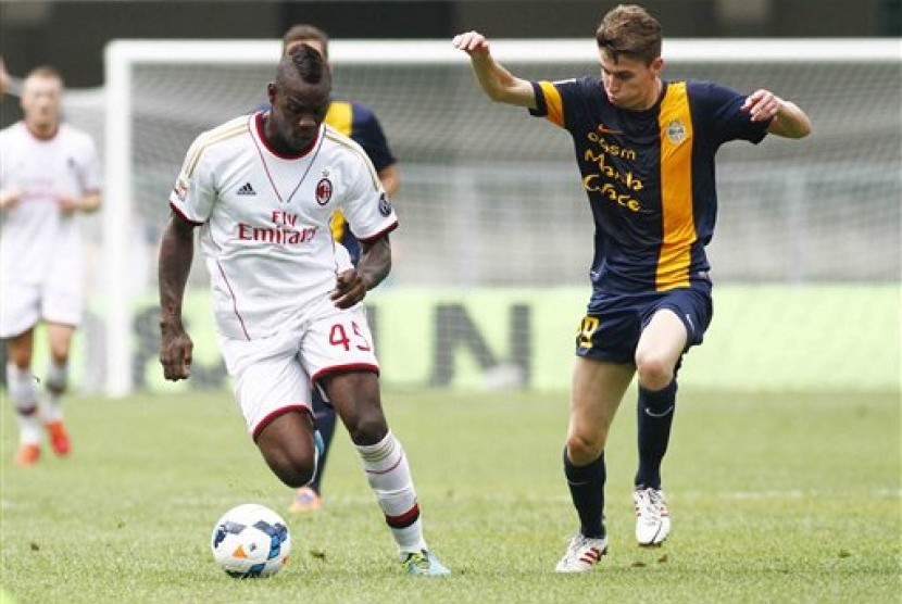 Striker AC Milan, Mario Balotelli (kiri), dibayang-bayangi bek Verona, Jorginho.