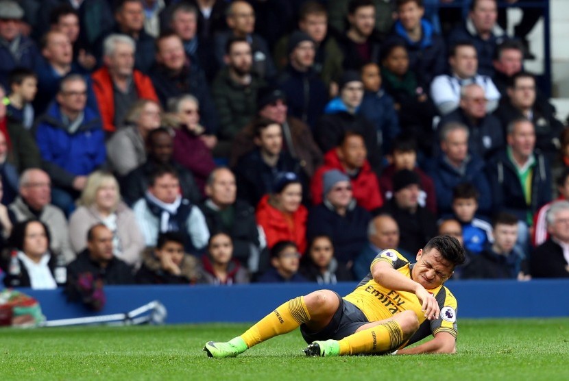  Striker Arsenal, Alexis Sanchez terkapar cedera pada laga lawan West Bromwich Albion di the Hawthorns, Sabtu (18/3). Sanchez tengah pekan ini akan membela timnas Cile.