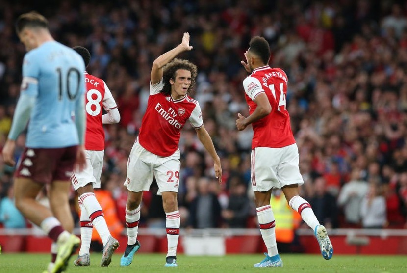 Striker Arsenal, Pierre Emerick-Aubameyang  (kanan) merayakan gol bersama Matteo Guendouzi pada laga Liga Primer Inggris melawan Aston Villa di Stadion Emirates. Arsenal menang 3-2.
