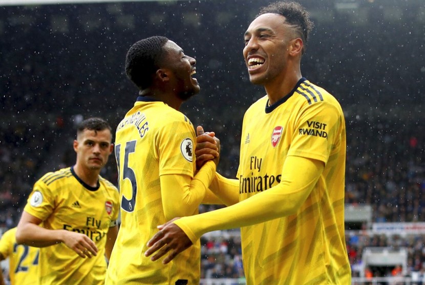 Striker Arsenal, Pierre-Emerick Aubameyang (kanan) merayakan golnya ke gawang Newcastle pada laga Liga Primer Inggris di St James Park, Ahad (11/8).