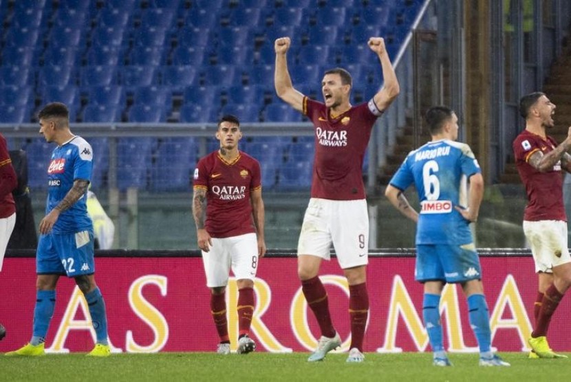Striker AS Roma, Edin Dzeko (tengah) merayakan kemenangan timnya atas Napoli pada laga Serie A di Stadion Olimpico, Sabtu (2/11).