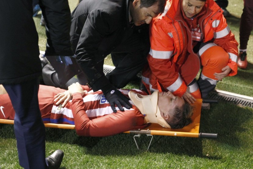 Striker Atletico Madrid, Fernando Torres ditandu ke luar lapangan pada laga La Liga lawan Deportivo La Coruna, di stadion Riazor, Jumat (3/3). Torres mengalami trauma kepala.