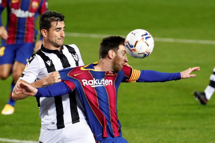 Striker Barcelona, Lionel Messi (kanan) berebut bola dengan bek Levante, Sergio Postigo pada laga La Liga, Senin (14/12) dini hari WIB. Barcelona menang 1-0 lewat gol Messi.