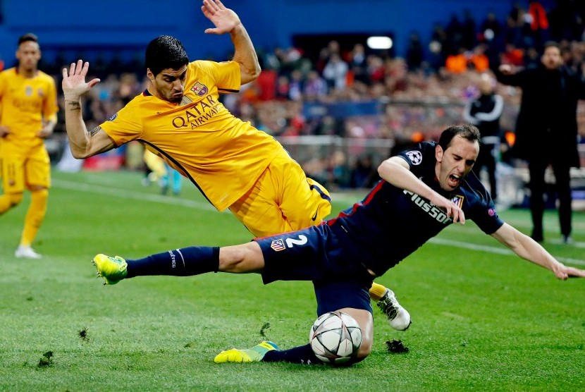 Striker Barcelona, Luis Suarez (kiri) saat berduel dengan bek Atletico Madrid, Diego Godin pada laga Liga Champions di Vicente Calderon,14 April 2016. Godin menyebut Suarez striker terbaik dunia.