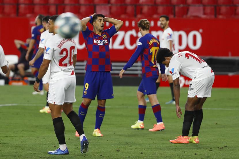 Striker Barcelona, Luis Suarez (tengah), tampak kecewa setelah timnya ditahan imbang Sevilla FC dalam laga La Liga Spanyol di Stadion Ramon Sanchez-Pizjuan, Sevilla, Spanyol, Jumat (19/6).