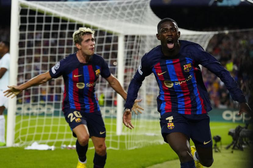 Striker Barcelona Ousmane Dembele (kanan) melakukan selebrasi setelah mencetak gol ke gawang Inter Milan pada laga penyisihan Grup C Liga Champions 2022/2023 di Camp Nou, Kamis (13/10/2022).