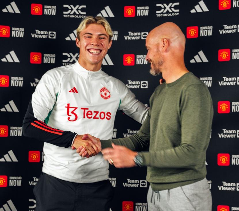 Striker baru Manchester United (MU) Rasmus Hojlund (kiri) bersalaman dengan pelatih MU Erik ten Hag seusai sesi tanda tangan kontrak sejak musim 2023/2024.