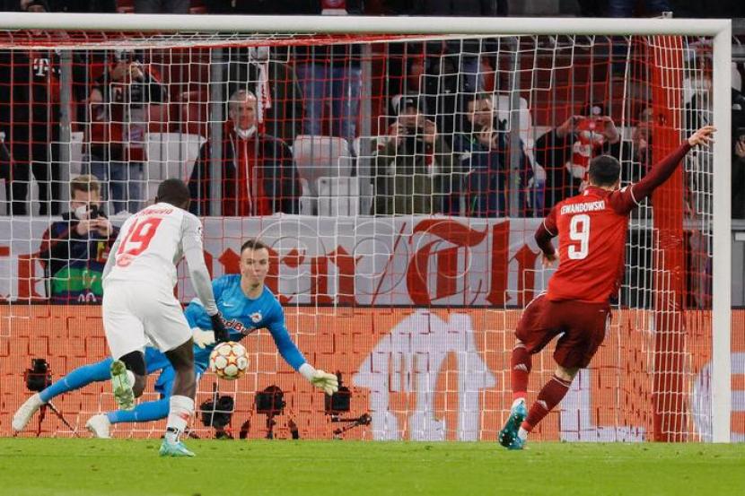 Striker Bayern Muenchen Robert Lewandowski (kanan) mencetak gol dari titik putih ke gawang RB Salzburg dalam laga leg kedua babak 16 besar Liga Champions, Rabu (9/3/2022). Lewandowski mencetak hattrick di laga itu untuk membawa Muenchen menang telak 7-1.