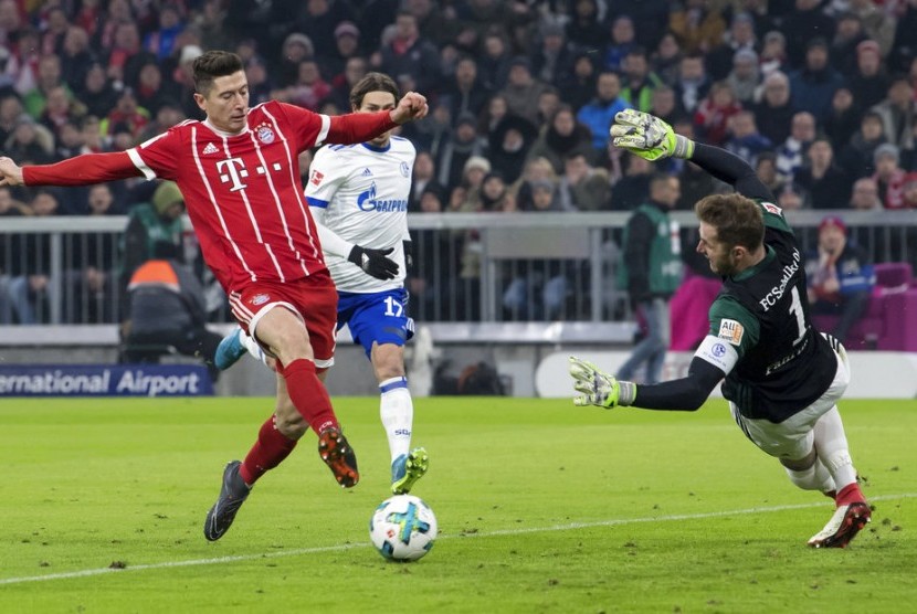 Striker Bayern Muenchen, Robert Lewandowski (kiri) saat mencetak gol ke gawang Schalke 04, Sabtu (10/2).
