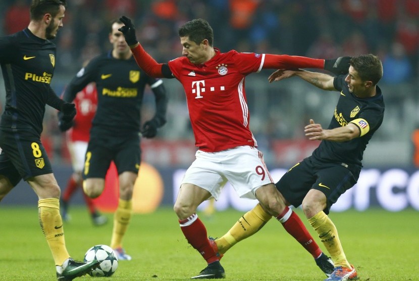 Striker Bayern Muenchen, Robert Lewandowski (tengah) dikawal beberapa pemain Atletico Madrid pada laga Liga Champions di Allianz Arena, Rabu (7/12) dini hari WIB. Lewandowski mencetak satu-satunya gol pada laga itu.