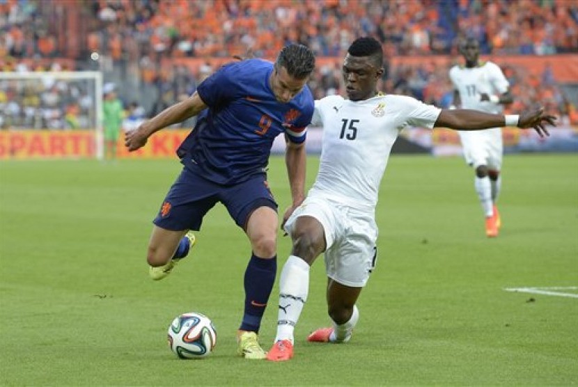 Striker Belanda, Robin Van Persie, tengah memperebutkan bola dengan pemain Ghana, Sumaila Rashid, pada sebuah laga uji coba jelang Piala Dunia 2014.