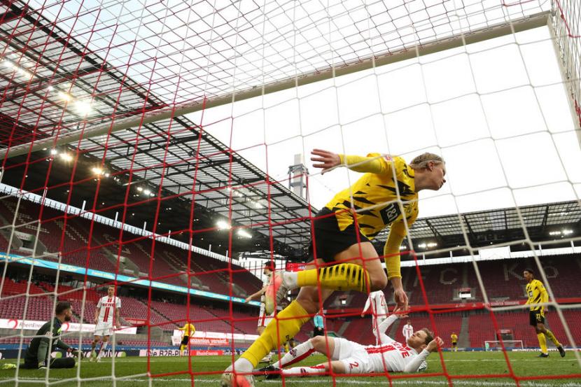 Striker Borussia Dortmund, Erling Haaland mencetak gol menit akhir ke gawang FC Cologne pada laga Bundesliga di Stadion Rhein Energie, Sabtu (20/3). Laga berakhir imbang 2-2. 