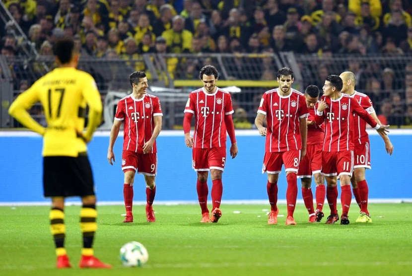 Striker Borussia Dortmund, Pierre-Emerick Aubameyang (kiri) menunggu kickoff saat para pemain Bayern Muenchen merayakan gol Robert Lewandowski (kedua kiri) pada laga Bundesliga di Signal Iduna Park, Ahad (5/11) dini hari WIB. Muenchen menang 3-1 pada laga ini.