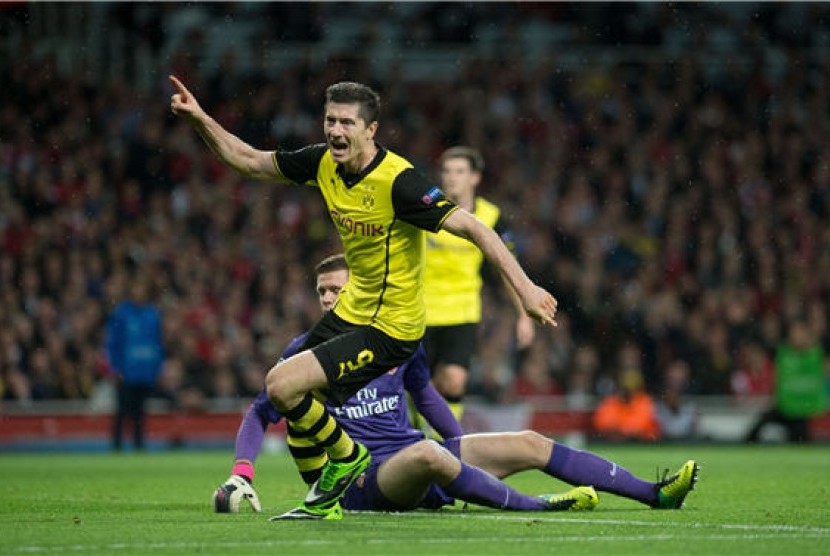 Striker Borussia Dortmund, Robert Lewandowski, merayakan golnya usai menjebol gawang Arsenal di laga Grup F Liga Champions di Stadion Emirates, London, Selasa (22/10).