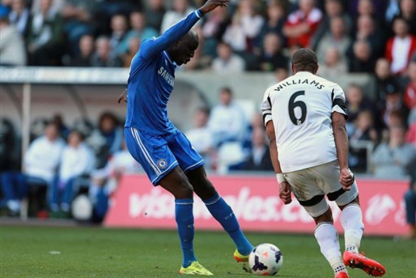 Striker Chelsea Demba Ba (kiri) melesakkan gol ke gawang Swansea City dalam lanjutan Liga Primer Inggris, Senin (14/4) dini hari.