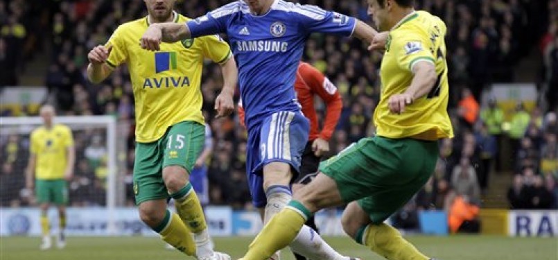 Striker Chelsea, Fernando Torres (tenga), dikepung pemain Norwich City, David Fox (kiri) dan Russell Martin, dalam laga Liga Primer Inggris di Stadion Carrow Road, Norwich, Sabtu (21/1). 