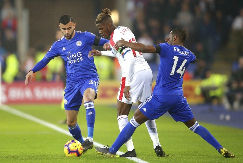 Striker Crystal Palace, Wilfried Zaha (tengah) dikawal dua pemain Leicester City, Rachid Ghezzal (kiri) dan Ricardo Pereira pada laga Liga Primer di Stadion King Power, Ahad (24/2) dini hari WIB. Leicester kalah 1-4.