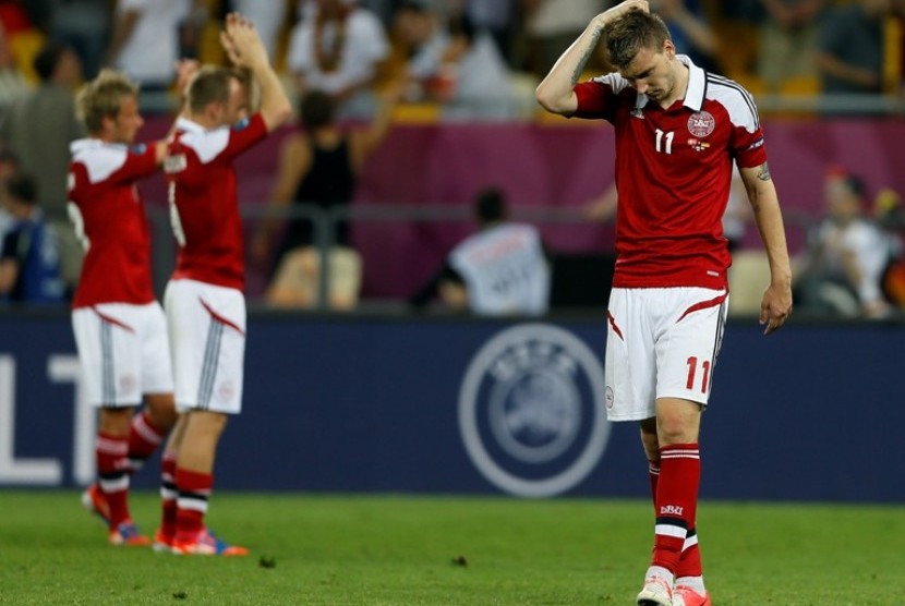 Striker Denmark Nicklas Bendtner (kanan) berjalan lesu setelah timnya tersingkir dari Piala Eropa 2012