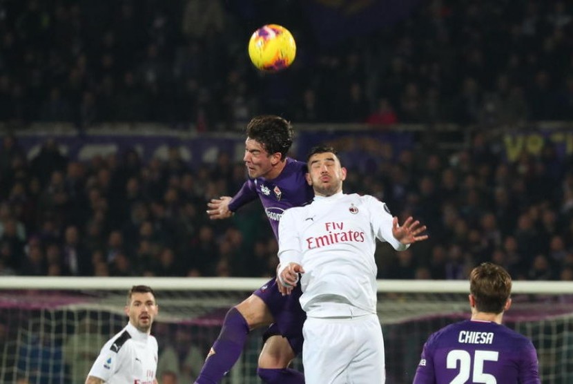 Striker Fiorentina, Dusan Vlahovic (kiri) berebut bola di udara dengan bek AC Milan, Theo Hernandez pada laga Serie A di Artemio Franchi, Ahad (23/2) dini hari WIB. Laga berakhir imbang 1-1.