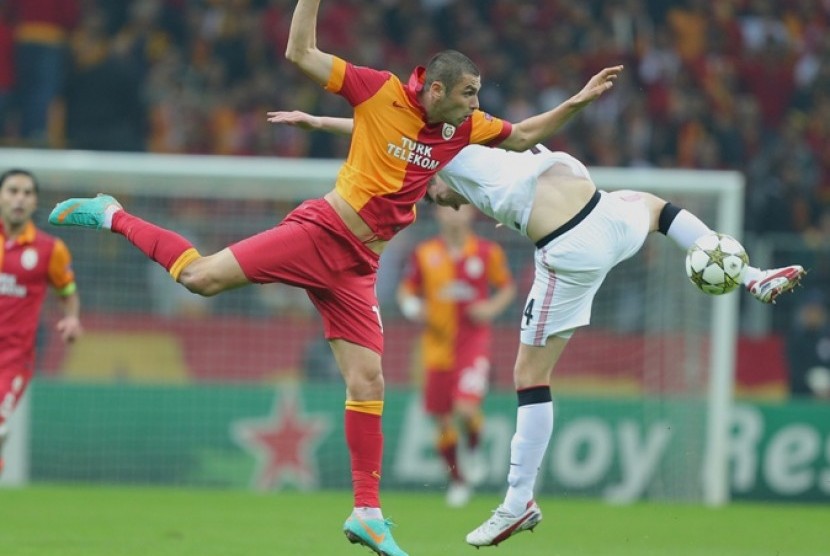 Striker Galatasaray Burak Yilmaz beradu dengan pemain MU Phil Jones saat lanjutan Liga Champions Eropa, Rabu (21/11) dini hari