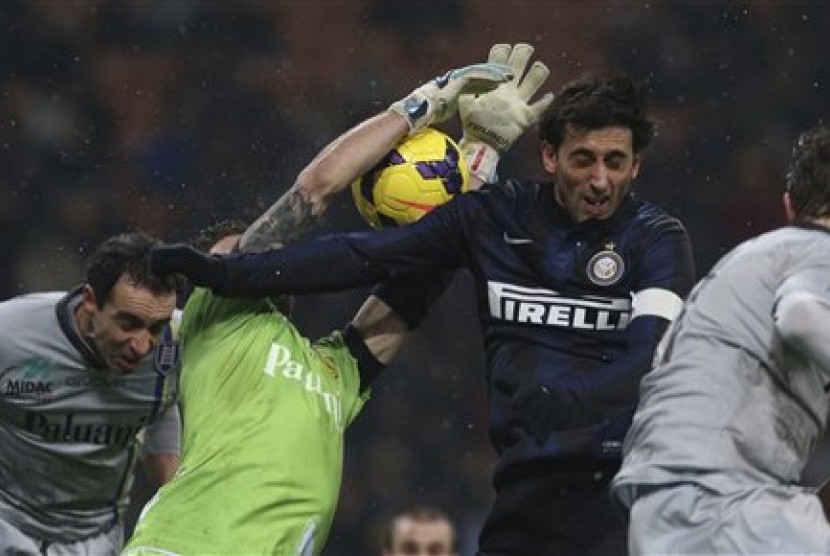 Striker Inter Milan, Diego Milito (tengah) berduel dengan kiper Chievo Christian Puggioni.