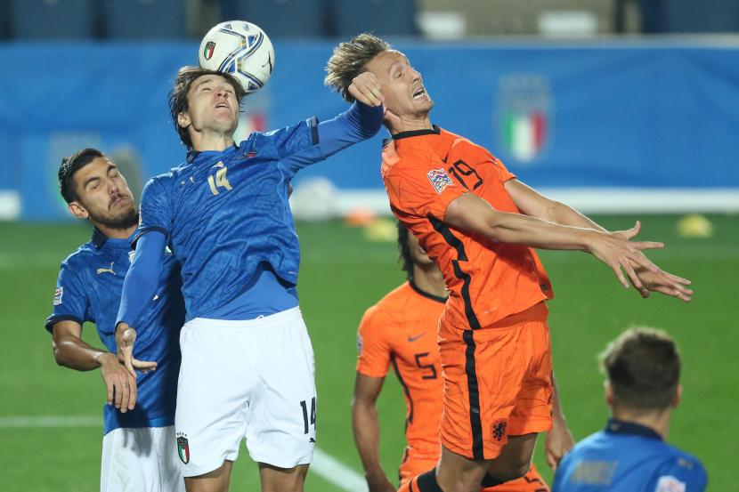Striker Italia Federico Chiesa (baju biru) berduel pemain Belanda Luuk de Jong saat kedua tim bentrok pada lanjutan Liga Bangsa-Bangsa di Bergamo, Kamis (15/10).