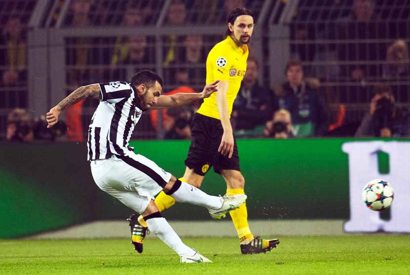 Striker Juventus, Carlos Tevez (kiri), melepaskan tembakan keras menjebol gawang Borussia Dortmund dalam laga ked babak 16 besar Liga Champions di Dortmund, Jerman, Rabu (18/3). 