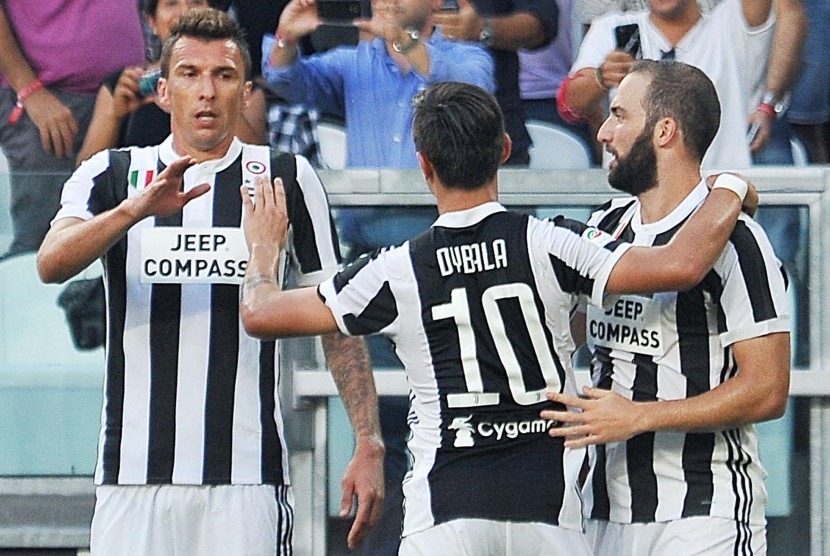 Striker Juventus, Gonzalo Higuain (kanan) merayakan golnya ke gawang Cagliari pada laga Serie A Stadion Allianz, Turin, Sabtu (19/8). Juventus menang 3-0. 