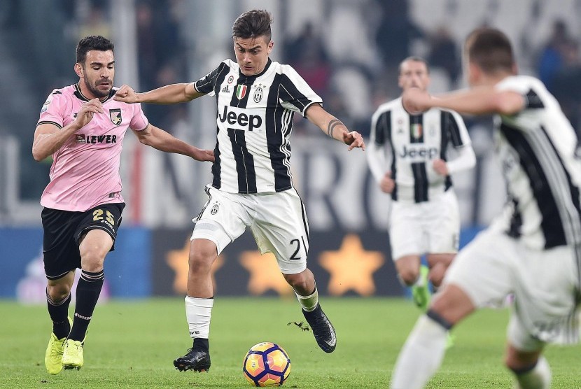 Striker Juventus, Paulo Dybala (tengah) menggiring bola pada laga Serie A lawan Palermo di J-Stadium, Sabtu (18/2) dini hari WIB. Juventus menang 4-1.