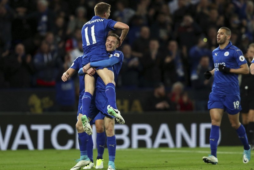 Striker Leicester, Jamie Vardy (tengah) menggendong Marc Albrighton seusai mencetak gol ke gawang Sunderland pada laga Liga Primer, di stadion King Power, Rabu (5/4) dini hari WIB. Leicester menang 2-0.