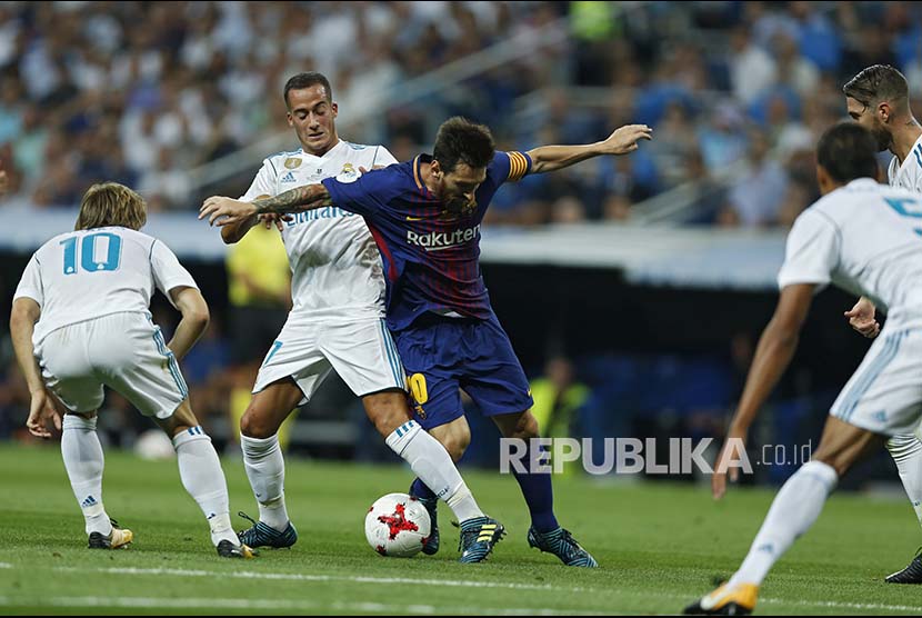 Striker Lionel Messi (kanan), dibayangi pemain Real Madrid Lucas Vazquez (kiri), pada pertandingan leg ke-2 Piala Super Spanyol antara Real Madrid vs Barcelona FC di Stadion Santiago Bernabeu, Madrid, Spanyol, Kamis (17/8) pagi.