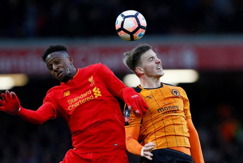 Striker Liverpool Divock Origi (kiri) berebut bola di udara dengan bek Wolverhampton Wanderers, Lee Evans pada laga Piala FA di Anfield, Sabtu (28/1). Liverpool tertinggal dua gol pada babak pertama.