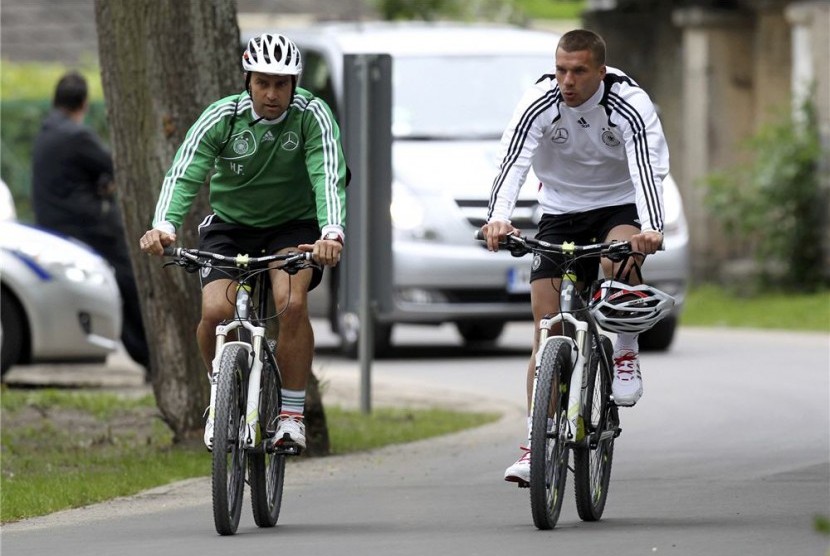 Pesepakbola Jerman Lukas Podolski (kanan) bersepeda. Berlin menambah jalur sepeda selama pembatasan sosial akibat pandemi virus corona. Ilustrasi.