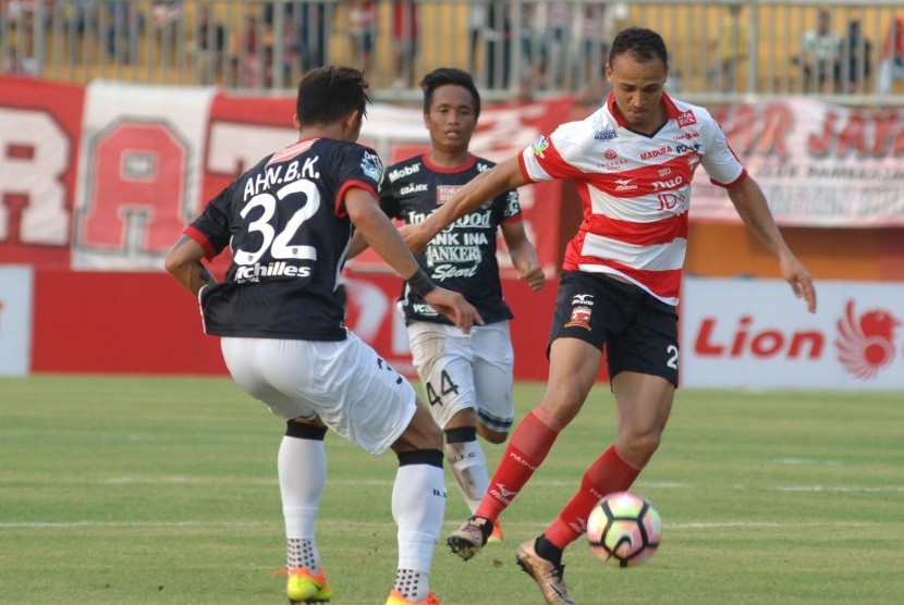 Striker Madura United (MU) FC Peter Osaze Odemwingie (kanan) melewati hadangan pesepak bola Bali United (BU) FC Ahn Byungkeon (kiri) dan I Gede Sukadana dalam (tengah) saat pertandingan Liga 1 di stadion Gelora Pamelingan (SGRP) Pamekasan, Jawa Timur, Ahad (16/4). 