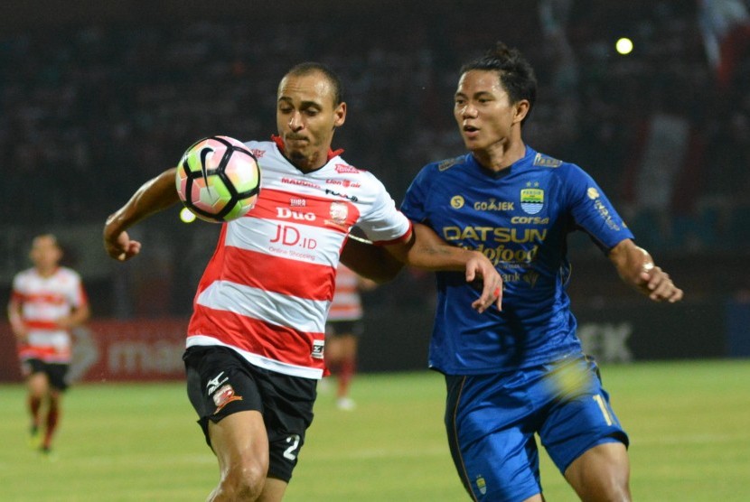 Striker Madura United (MU) Peter Osase Odemwingie (kiri) berusaha melewati bek Persib Bandung Ahmad Jufrianto (kanan) saat pertandingan Liga 1 di Stadion Gelora Ratu Pamelingan (SGRP) Pamekasan, Jawa Timur, Ahad (9/7). 