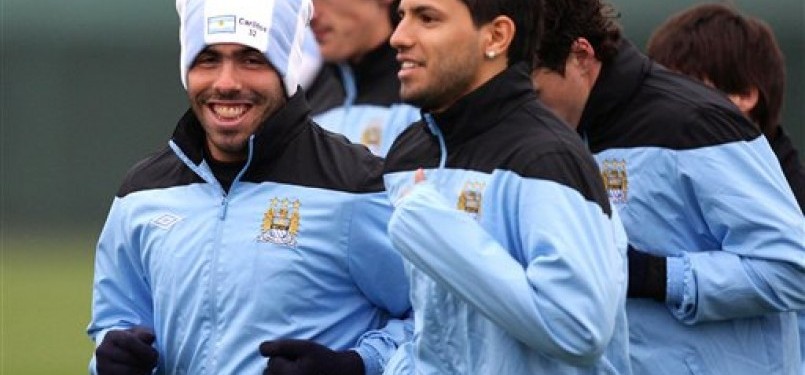 Striker Manchester City, Carlos Tevez (kiri), tersenyum saat menjalani sesi latihan bersama rekan setimnya di Carrington, Manchester, Rabu (14/3). 