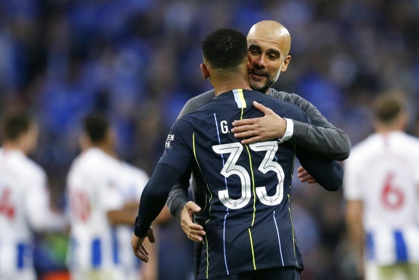 Striker Manchester City, Gabriel Jesus berpelukan dengan pelatih, Pep Guardiola usai memenangkan laga semifinal Piala FA melawan Brighton & Holve Albion di Stadion Wembley, Ahad (7/4) dini hari WIB. City menang 1-0.