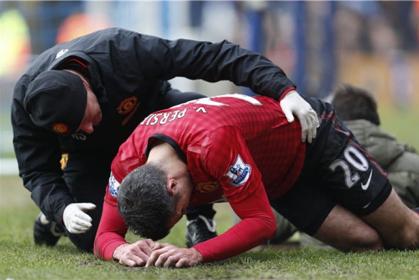 Striker Manchester United, Robin Van Persie (kanan), mengalami cedera saat menghadapi Queens Park Rangers di laga Liga Primer Inggris di Loftus Road,London, Sabtu (23/2). 