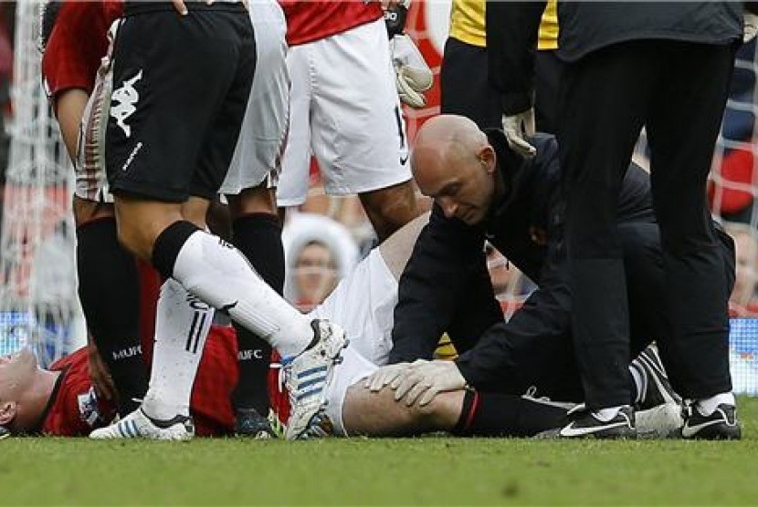 Striker Manchester United, Wayne Rooney, menerima perawatan saat mengalami cedera lutut saat laga menjamu Fulham di Stadion Old Trafford, Manchester, pada 25 Agustus lalu. 