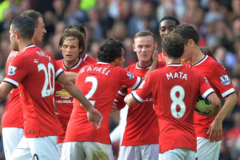 Striker Manchester United, Wayne Rooney (tengah), mendapat selamat dari rekan setim usai menjebol gawang Queens Park Rangers dalam laga Liga Primer Inggris di Old Trafford, Manchester, Ahad (14/9). 