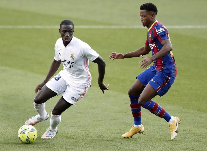  Striker muda Barcelona Ansu Fati (kanan) duel melawan pemain Real Madrid Ferland Mendy dalam laga el Clasico La Liga Spanyol di Camp Nou, Barcelona, Sabtu (24/10). Dalam laga ini, Madrid unggul 3-1 atas Barca.