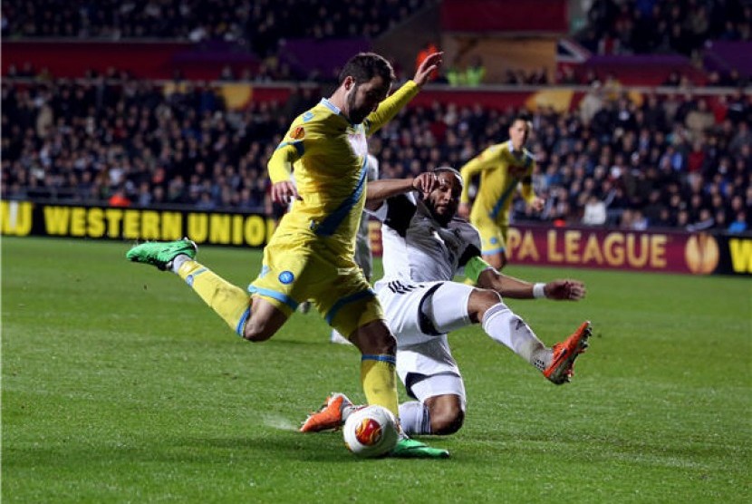 Striker Napoli, Gonzalo Higuain (kiri), melepaskan tembakan saat menghadapi Swansea City dalam laga Liga Europa. 