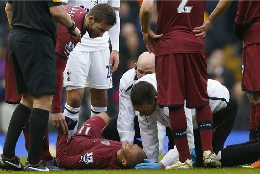 Striker Newcastle United, Yoan Gouffran, terbaring di lapangan saat mendapat pertolongan medis dalam laga Liga Primer Inggris lawan Tottenham Hotspur di White Hart Lane, London, Sabtu (9/2). 