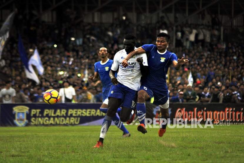 Striker Persib Bandung Ezechiel Ndouassel (tengah) dihadang dua gelandang Perserang FC Junaedi (kanan) dan Okto Nanda (kiri) saat bermain pada Laga Persahabatan kedua klub di Stadion Maulana Yusuf Serang, Banten, Kamis (1/3).