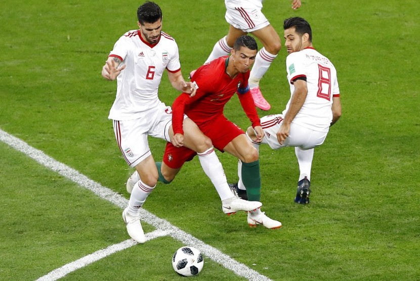 Striker Portugal, Cristiano Ronaldo (tengah) dijepit dua pemain Iran pada laga penyisihan Piala Dunia 2018, Mordovia Arena di Saransk, Rusia, Selasa (26/6) dini hari WIB. Laga berakhir imbang 1-1.