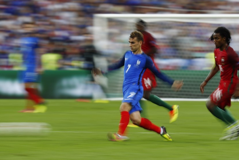 Striker Prancis Antoine Griezmann sedang berusaha melepaskan diri dari kawalan pemain Portugal Renato Sanches