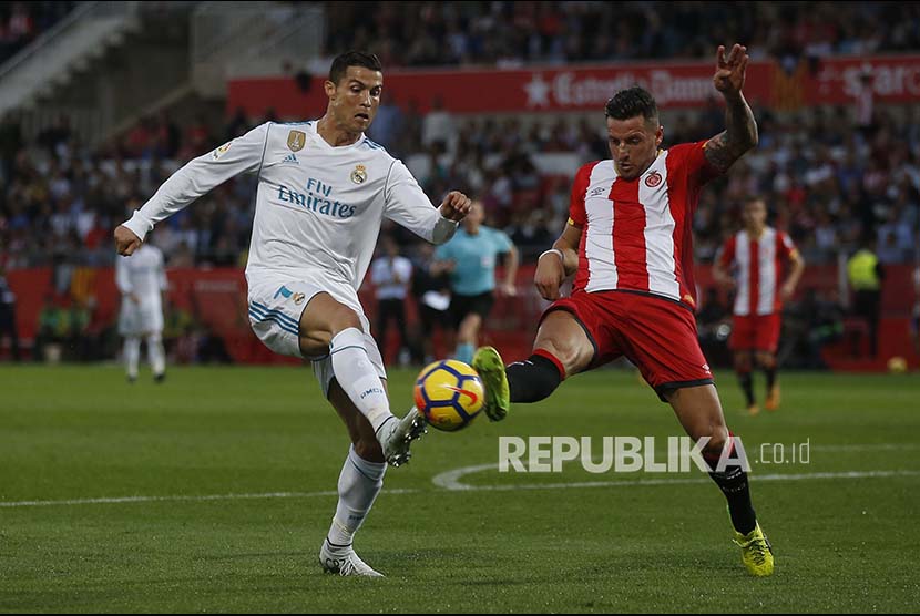 Striker Real Madrid Cristiano Ronaldo berebut bola dengan pemain Girona Aday Benitez pada pertandingan  Laliga di Montilivi stadium in Girona, Spanyol.