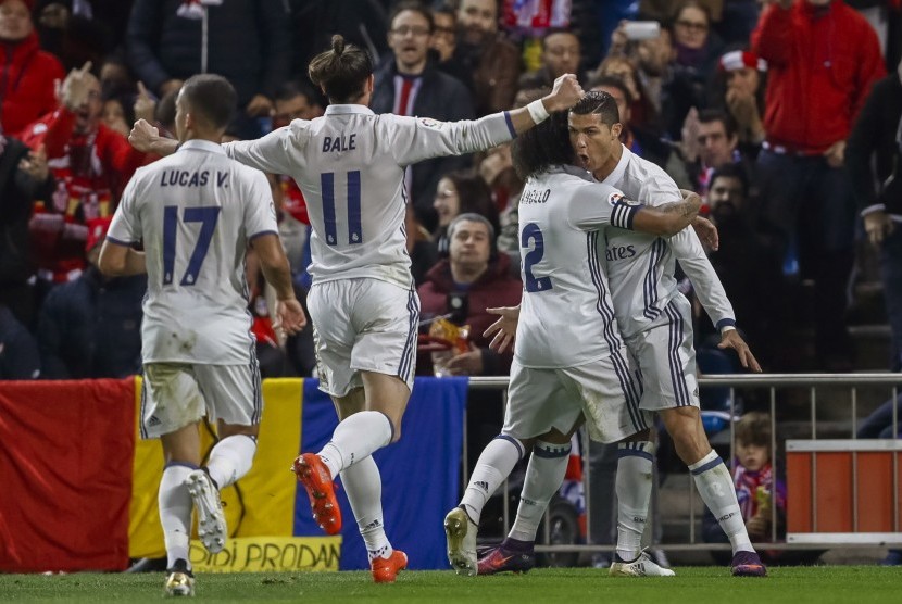 Striker Real Madrid, Cristiano Ronaldo (kanan) merayakan golnya bersama rekan setim pada laga La Liga lawan Atletico Madrid di Vicente Calderon, Ahad (20/11) dini hari WIB. Madrid unggul 1-0 pada babak pertama.