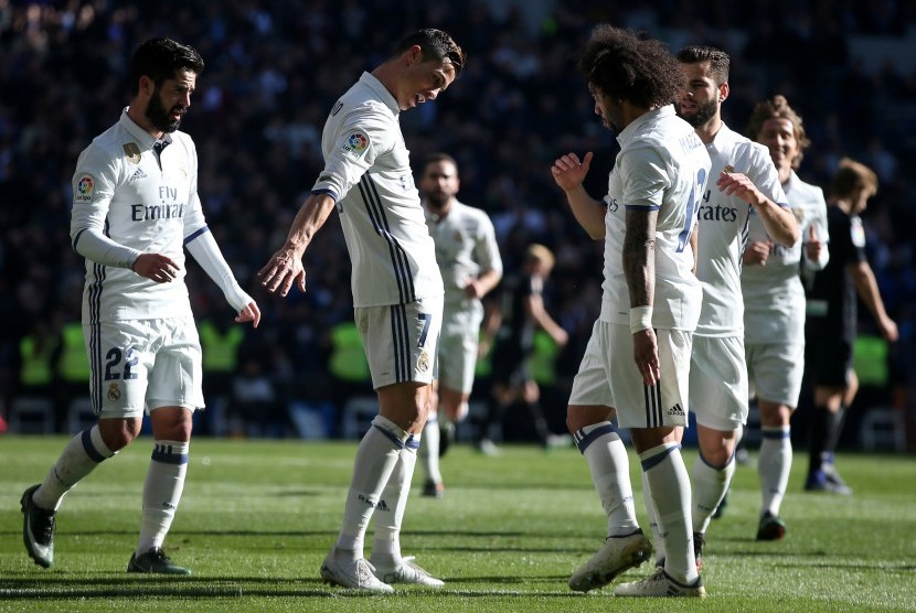 Striker Real Madrid Cristiano Ronaldo (kedua kiri) merayakan golnya ke gawang Granada dalam laga La Liga di Santiago Bernabeu, Sabtu (7/1). Madrid menang telak 5-0.