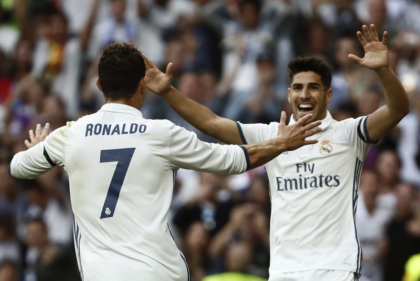 Striker Real Madrid, Cristiano ROnaldo (kiri) merayakan gol bersama Marco Asensio pada laga La Liga lawan Sevilla di Santiago Bernabeu, Ahad (14/5). Madrid menang 4-1.